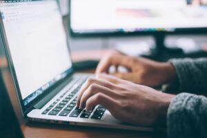 Someone typing on their laptop.