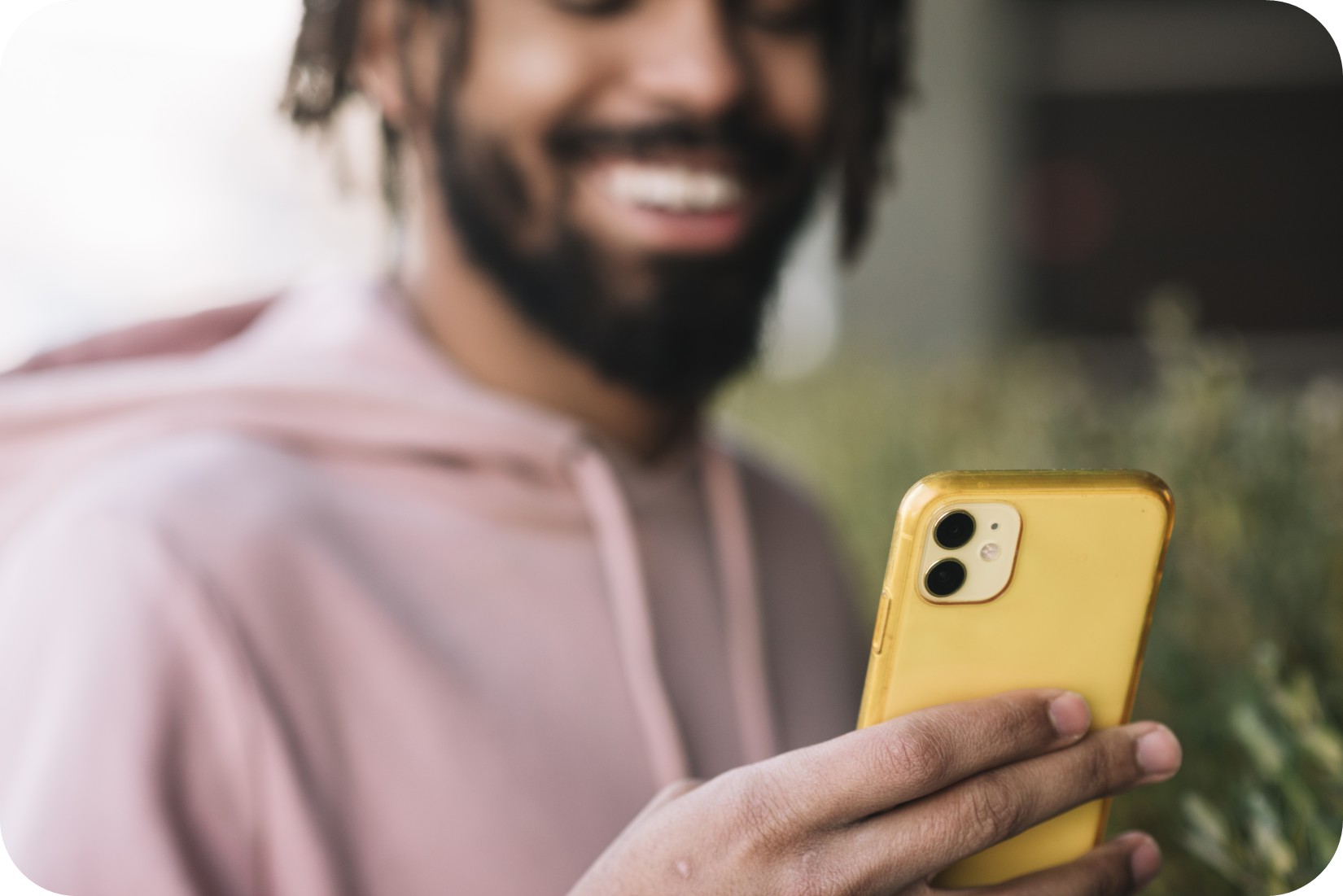 Homme souriant qui regarde son téléphone.